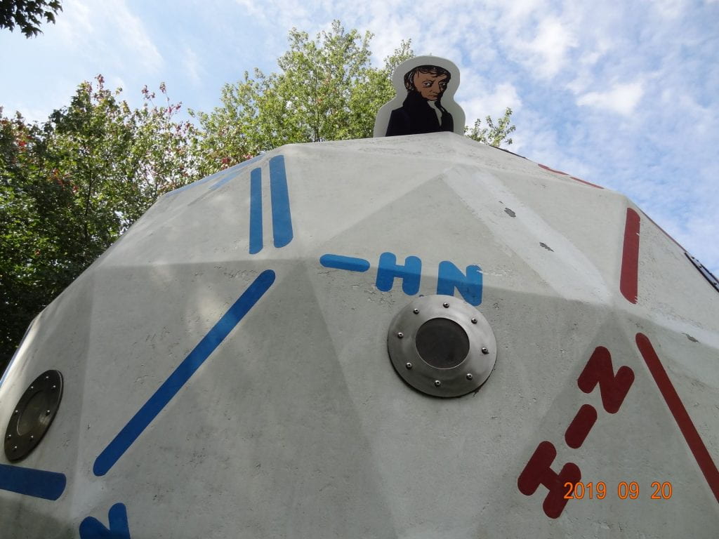 Life-size cut-out of Avogadro placed above a large white dome with molecules 