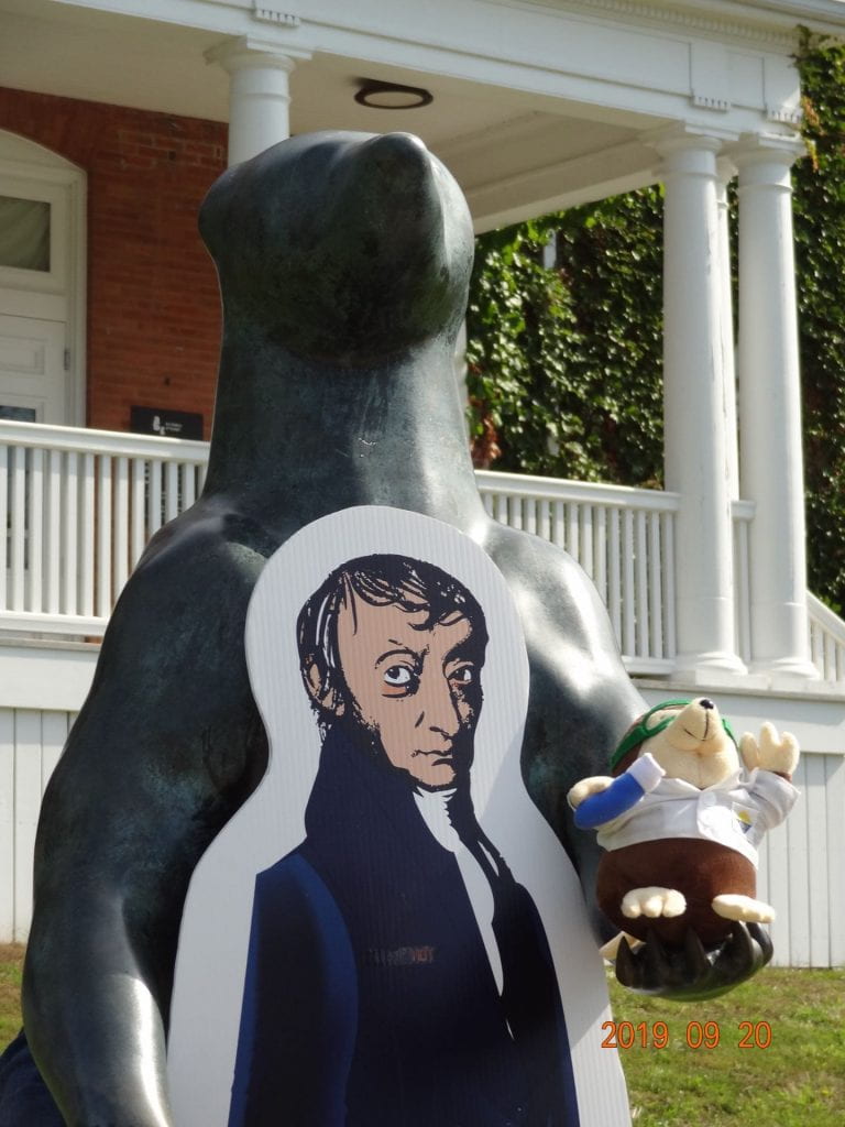 a statue of a standing bear holding a mole with a life-size Avogadro cutout