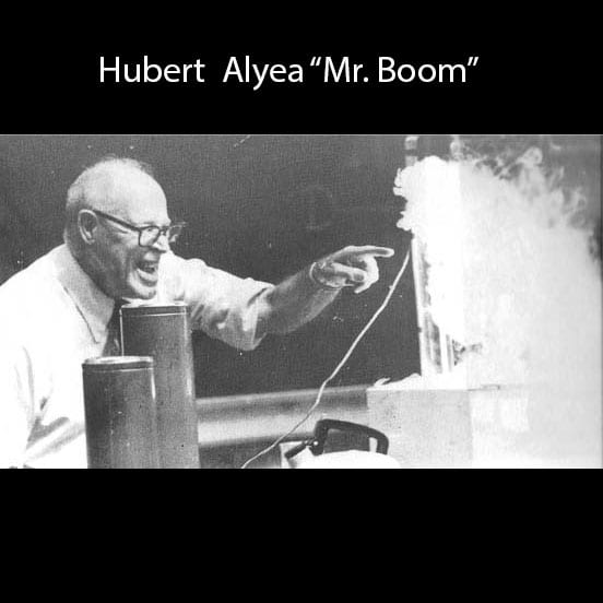 Hubert Alyea smiling and pointing at a smokey demonstration 